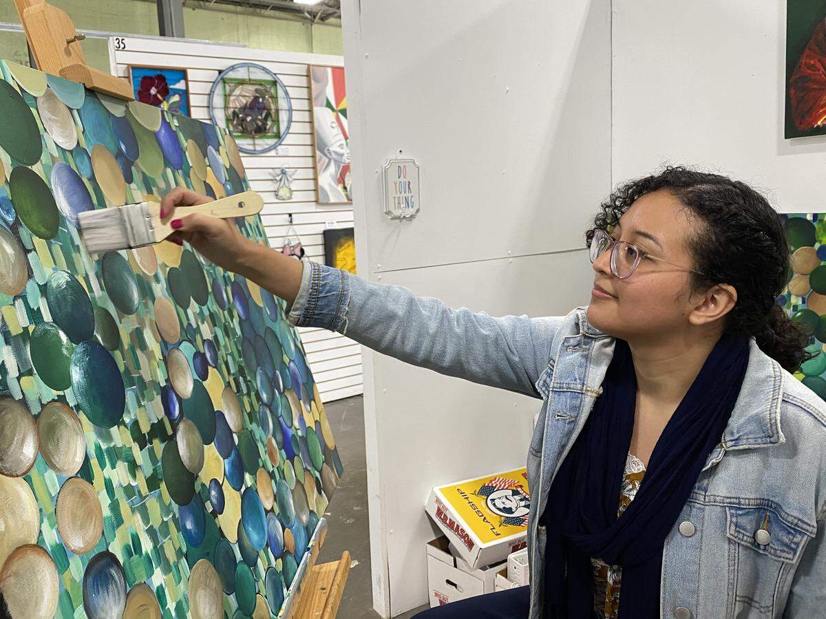 Charlotte artist Rosa Renteria Jimenez in her studio at Charlotte Art League. This painting is called “Fragile 1.”