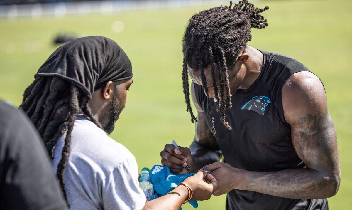 Carolina Panthers Jaycee Horn, right, signs an autograph during the joint practice with the Baltimore Ravens in Spartanburg, S.C., on Thursday, August 19, 2021.