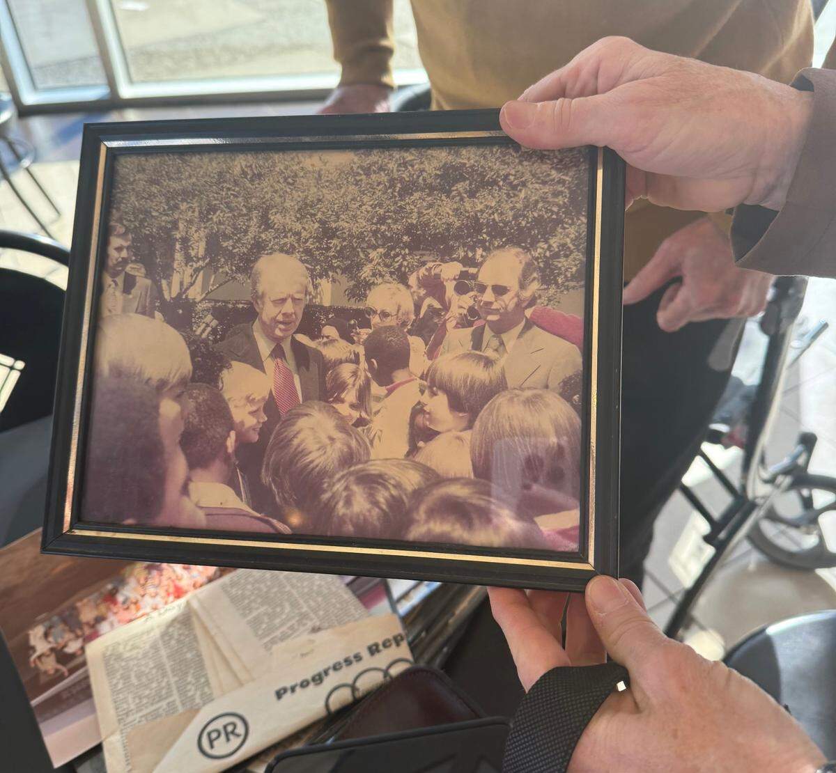Alice Weaver shows off a photo taken the day she and her classmates met Jimmy Carter at the White House. “I’m the girl peeking out from behind his shoulder,” she said.