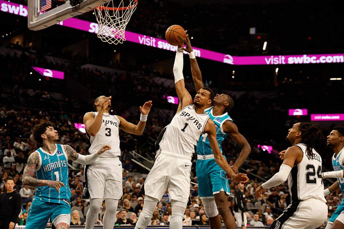 Victor Wembanyama of the San Antonio Spurs battles Brandon Miller of the Charlotte Hornets for a rebound in the first half at Frost Bank Center.