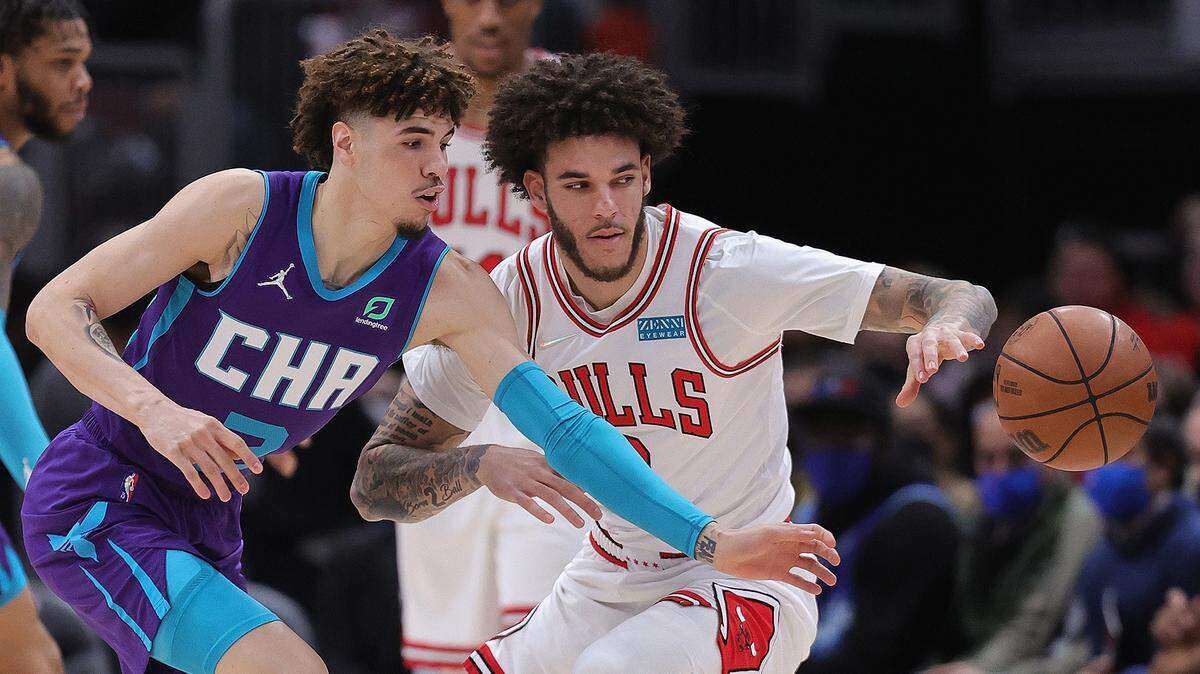 LaMelo Ball (2) of the Charlotte Hornets and brother Lonzo Ball (2) of the Chicago Bulls chase a loose ball at United Center on November 29, 2021, in Chicago, Illinois. (Jonathan Daniel/Getty Images/TNS)