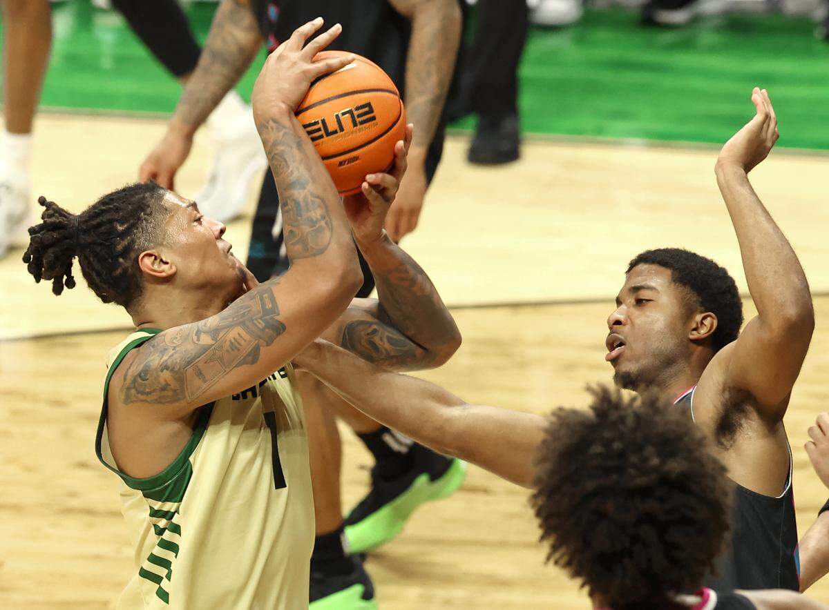 Charlotte 49ers forward Giancarlo Rosado, left, takes a hand to the face from a Florida Atlantic University defender as Rosado drives into the lane during action on Wednesday, January 8, 2025 at Halton Arena on the campus of UNC Charlotte in Charlotte, NC. FAU defeated Charlotte 75-64.
