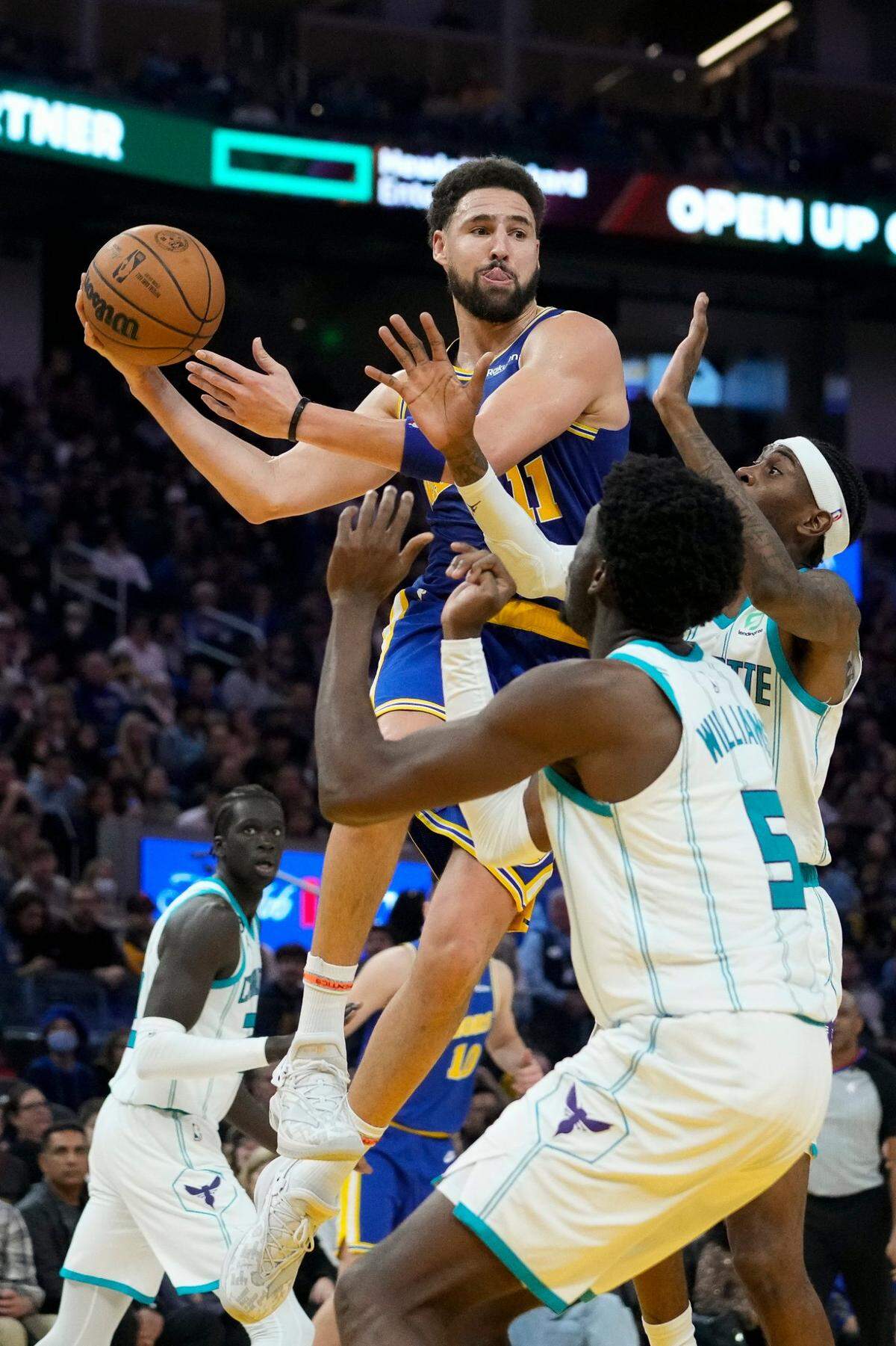 Golden State Warriors guard Klay Thompson (11) passes the ball while defended by Charlotte Hornets forward Jalen McDaniels, right, and center Mark Williams (5) during the second half of an NBA basketball game in San Francisco, Tuesday, Dec. 27, 2022. (AP Photo/Godofredo A. Vásquez)