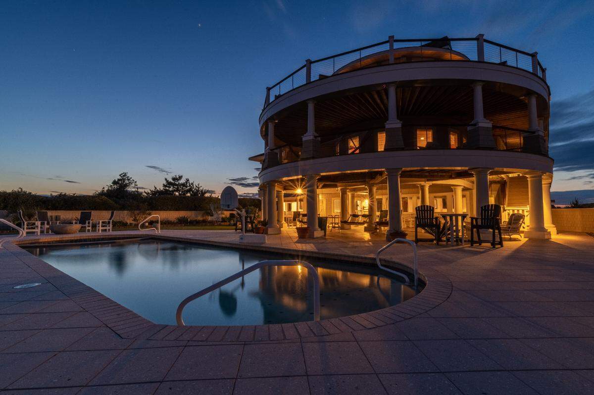 The saltwater pool is complete with a poolside wet bar complete with a refrigerator, sink and television.