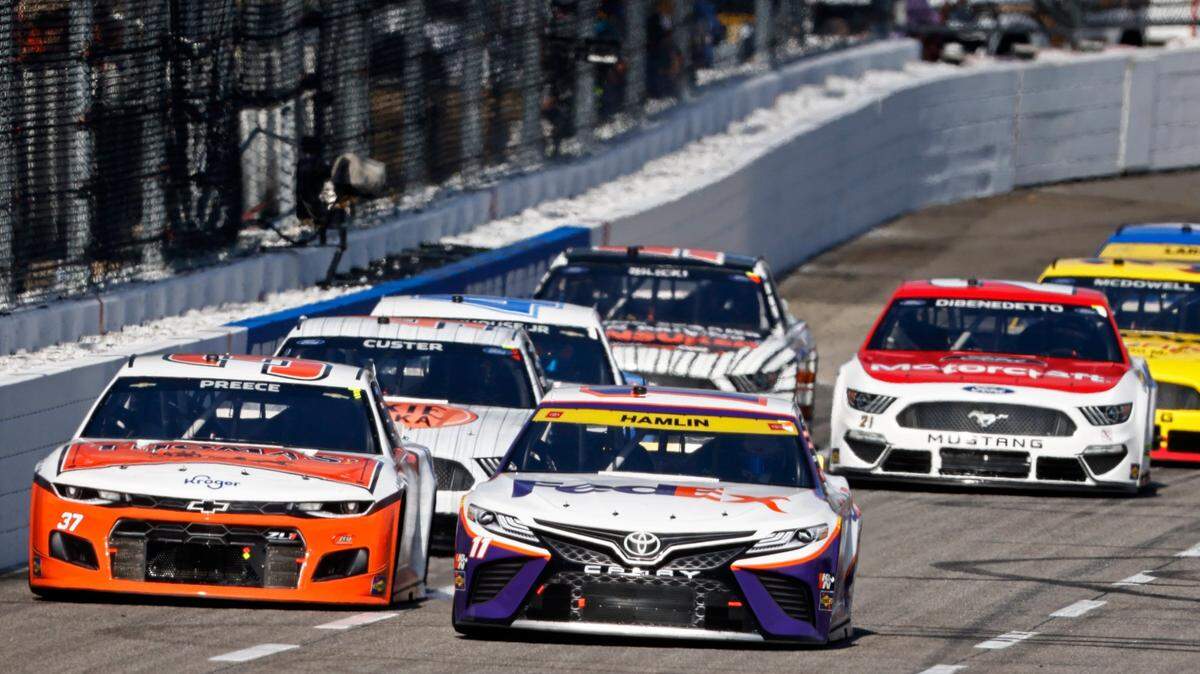 Denny Hamlin (11) leads Ryan Preece (37) and the rest of the field during a NASCAR Cup Series auto race, Sunday, Oct. 31, 2021, in Martinsville, Va. (AP Photo/Wade Payne)