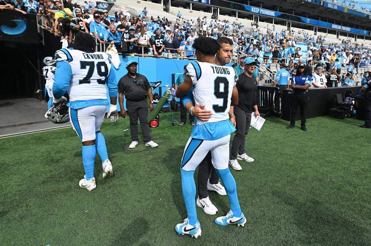 Carolina Panthers head coach Dave Canales, right, hugs quarterback Bryce Young, center, following the team’s 26-3 loss to the Los Angeles Chargers on Sunday, September 15, 2024 at Bank of America Stadium in Charlotte. Canales said afterward that “Bryce is our quarterback.”