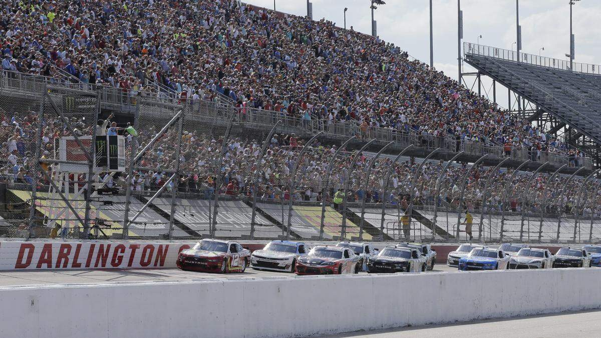 FILE - In this Aug. 31, 2019, file photo, Ryan Blaney leads the field to the start the NASCAR Xfinity Series auto race at Darlington Raceway in Darlington, S.C. NASCAR will resume its season without fans starting May 17 at Darlington Raceway in South Carolina. As NASCAR speeds back to the race track during the coronavirus pandemic the series has a heavy responsibility to set a safety standard that doesn’t slow the return of other sports. (AP Photo/Terry Renna, File)