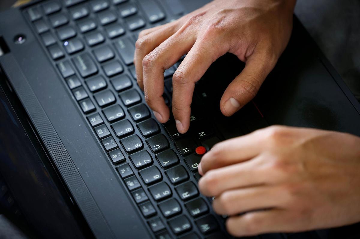Arturo Pineda of Charlotte processes asylum applications from a laptop on their back porch for his work as a paralegal.