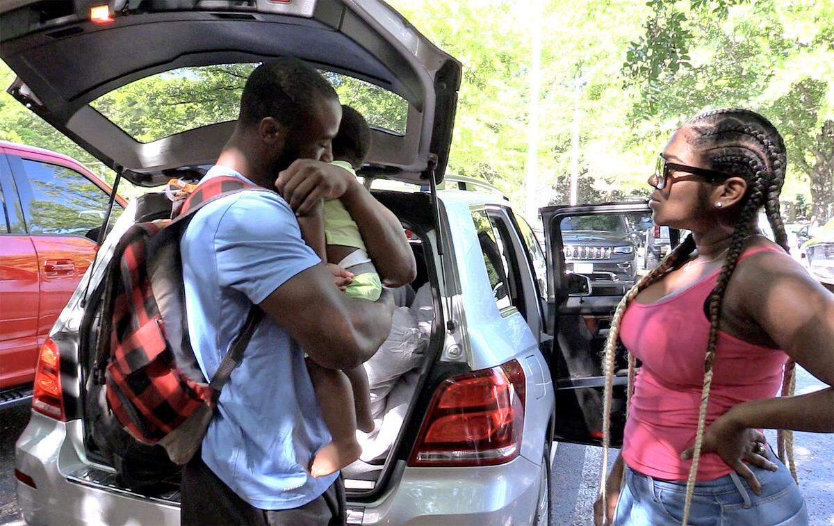 Elijah Hood, left, hugs his son, Elisha “JuJu” Hood, center, and says goodbye as Hood’s finance’ Ne’Shei Franklin, right, looks on at Wofford College in Spartanburg on Wednesday.