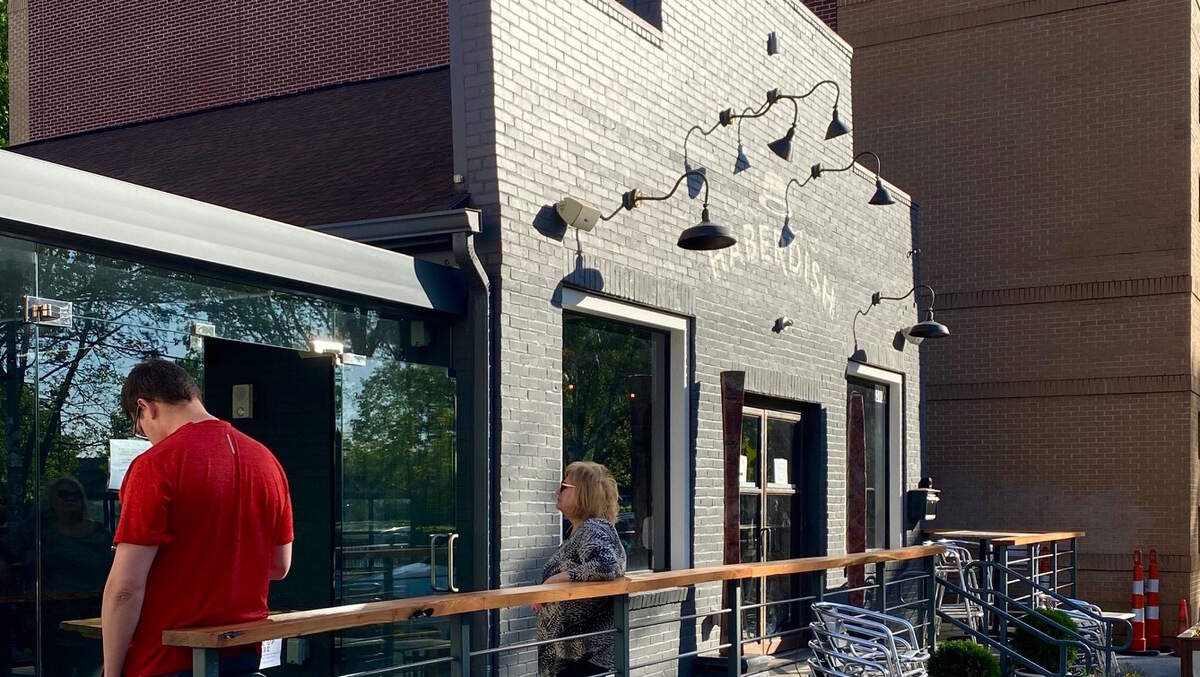 Customers wait outside Haberdish to pick up orders.