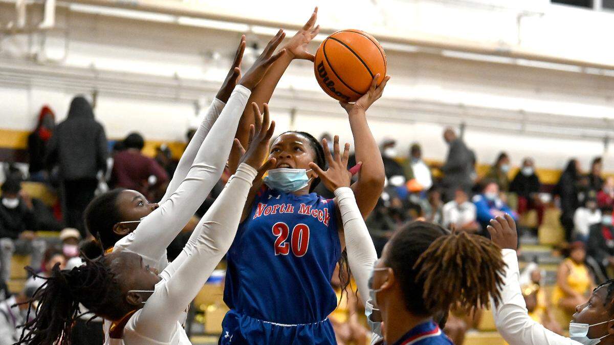 North MeckÕs Alisha Harris, center, fights to get her shot off over the West Charlotte defense during second half action on Friday, January 14, 2022 at West Charlotte High School.