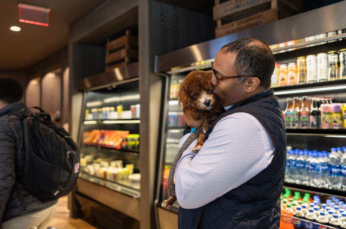 Benjamin Bowman waits in line to get a drink at Coco and the Director with his service dog, Posh, in Charlotte, N.C., on Wednesday, January 16, 2025.