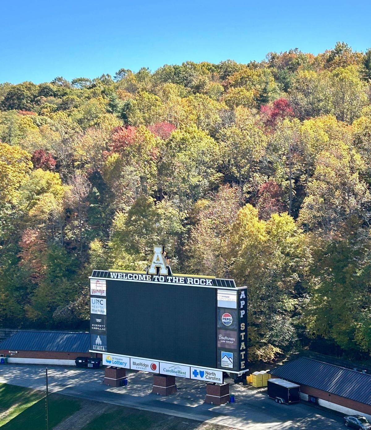 Appalachian State’s football scoreboard is surrounded by trees beginning to change color on Oct. 21, 2024.