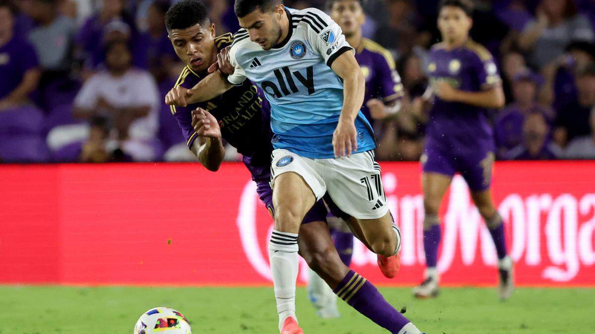Oct 27, 2024; Orlando, Florida, USA; Charlotte FC forward Liel Abada (11) dribbles against Orlando City midfielder Wilder Cartagena (16) during the first half in a 2024 MLS Cup Playoffs Round One match at Inter&Co Stadium.
