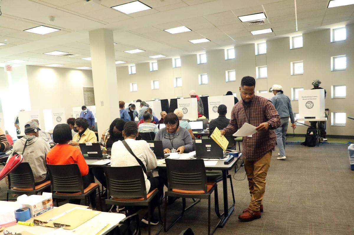 Voters and election officials participate in early voting at the Allegra Westbrooks Regional Library polling place in Charlotte, N.C., on October 17, 2024.
