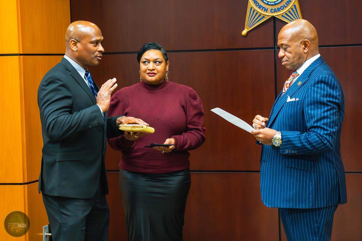 Former Mecklenburg Sheriff Chief Deputy Kevin Canty, left, being sworn in last year. Canty resigned and accused Sheriff Garry McFadden, right, of abusing his power.