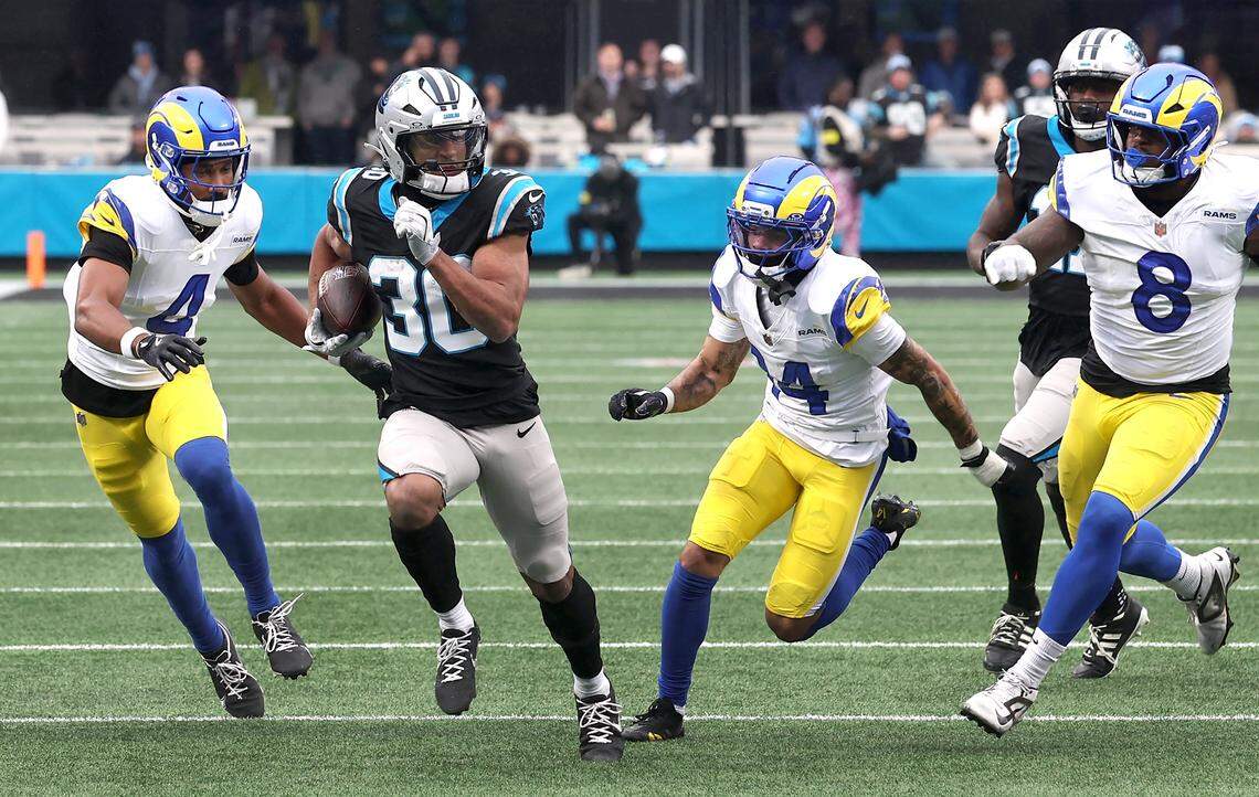 Carolina Panthers running back Chuba Hubbard, center, breaks free of the Los Angeles Rams defense on a touchdown run during action at Bank of America Stadium in Charlotte, NC on Sunday, November 30, 2025.
