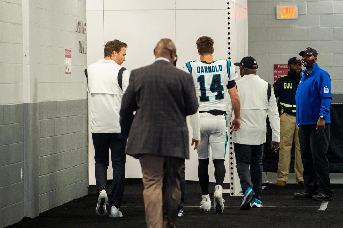 Panthers quarterback Sam Darnold, second from right, walks to the locker room with the team athletic training staff after getting drilled by Falcons inside linebacker Foyesade Oluokun. Darnold suffered a concussion on the play.