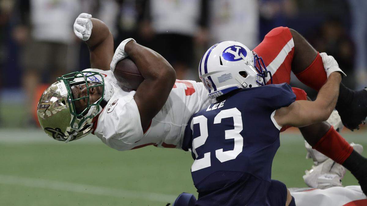 East running back Benny LeMay, of Charlotte, (32) scores against the West safety Austin Lee, of BYU, (23) during the first half of the East West Shrine football game Saturday, Jan. 18, 2020, in St. Petersburg, Fla. (AP Photo/Chris O’Meara)