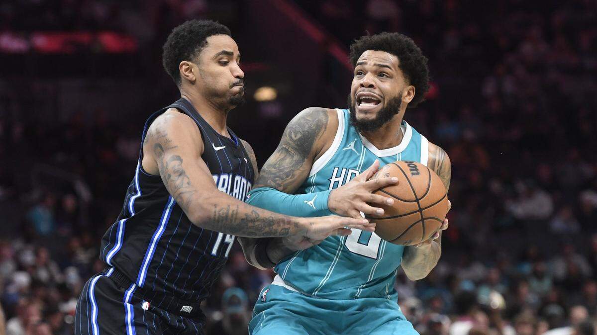 Charlotte Hornets forward Miles Bridges (0) looks to pass as he is defended by Orlando Magic guard Gary Harris (14) during the second half at the Spectrum Center.