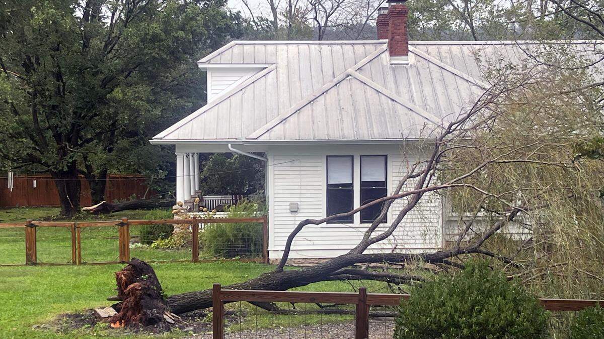 A downed tree blocks the road in front of a house north of Asheville.