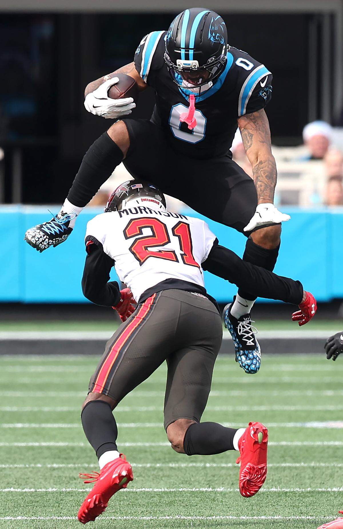 Carolina Panthers tight end Ja’Tavion Sanders jumps over Tampa Bay Buccaneers cornerback Benjamin Morrison following a pass reception in 2025. 