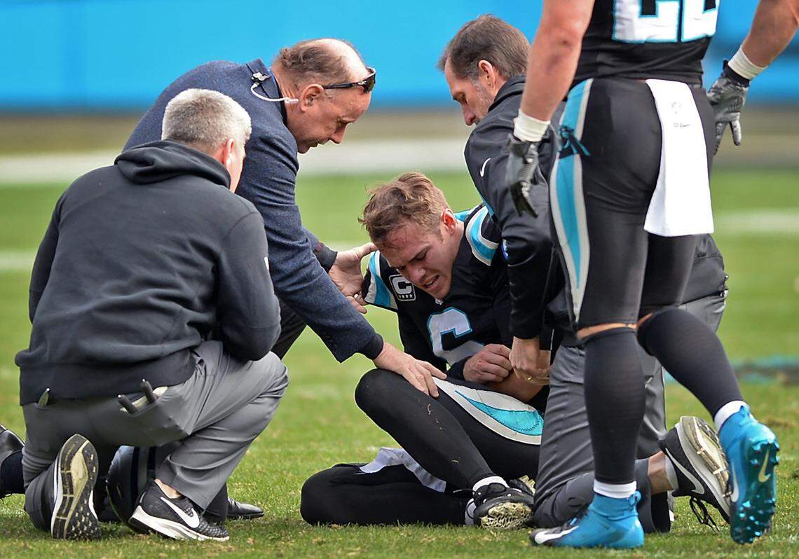 Carolina Panthers quarterback Taylor Heinicke holds his left arm as he is attended to by team physicians. Heinicke started one game for the Panthers in 2018, getting hurt in the second quarter.