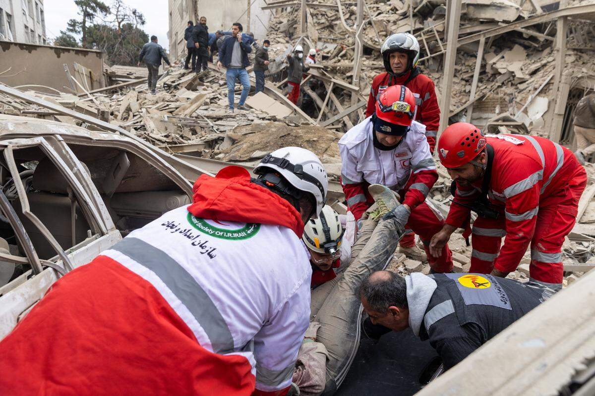 TEHRAN, IRAN - MARCH 16: (EDITORS NOTE: Image contains graphic content) Emergency workers lift an injured woman onto a stretcher following a strike on a residential building on March 16, 2026 in central Tehran, Iran. The United States and Israel continued their joint attack on Iran that began on February 28. Iran retaliated by firing waves of missiles and drones at Israel, and targeting U.S. allies in the region. (Photo by Getty Images)