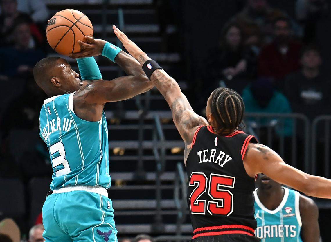 Charlotte Hornets guard Terry Rozier, left, releases a three-point shot as Chicago Bulls guard Dalen Terry, right, tries to disrupt Rozier’s rythm during first half action on Monday, January 8, 2024 at Spectrum Center in Charlotte, NC.