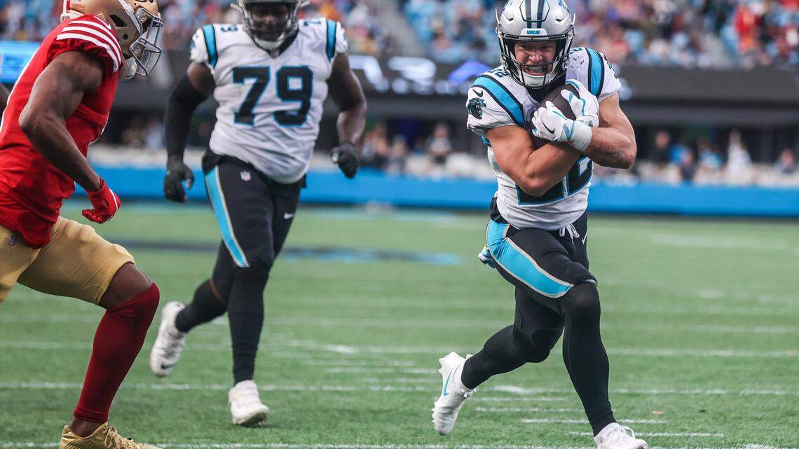 Panthers running back Christian McCaffrey protects the ball as he runs toward the end zone during the game against the 49ers at Bank of America Stadium on Sunday, October, 9, 2022.