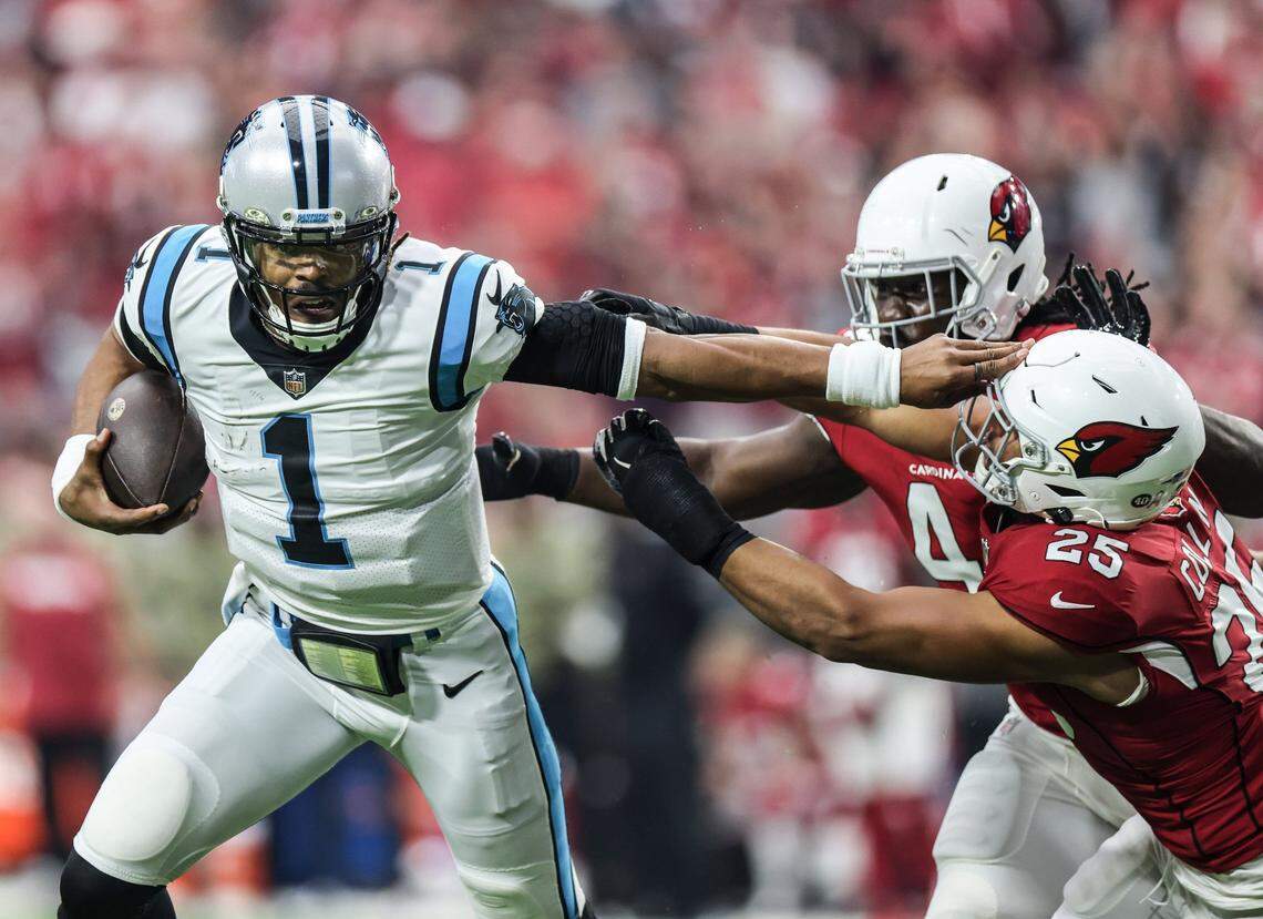 Carolina Panther quarterback Cam Newton pushes away an Arizona defender on his touchdown run Sunday.