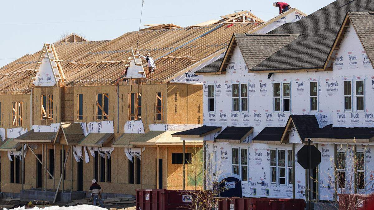 En unas casas adosadas en construcción cerca del barrio University City de Charlotte, los obreros se enfrentan a lo que puede ser un trabajo peligroso: poner el techo a las viviendas. Ninguno de los trabajadores lleva arnés de seguridad.