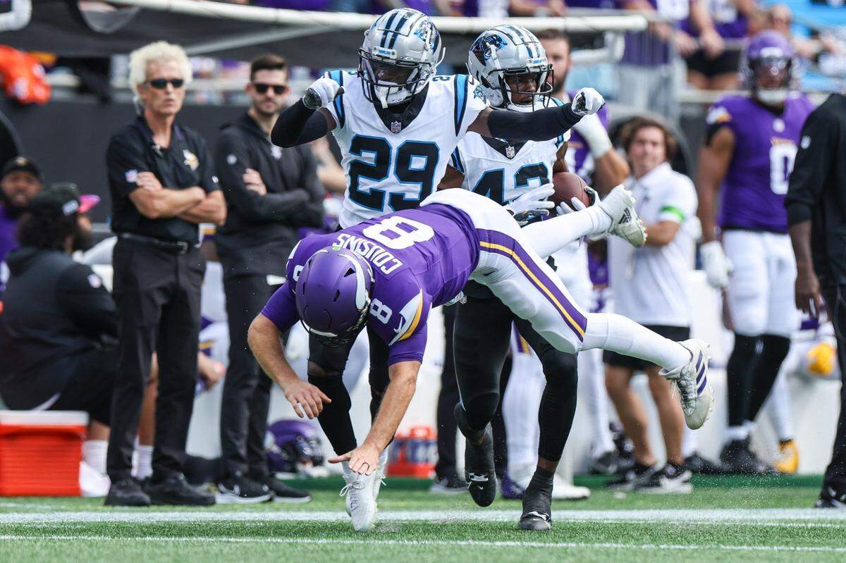 Minnesota quarterback Kirk cousins is tossed out of the way by Panthers defensive back D’Shawn Jaminson as teammate Sam Franklin, Jr. runs an interception to the end zone during the game at Bank of America Stadium on Sunday, October 1, 2023 in Charlotte, NC.