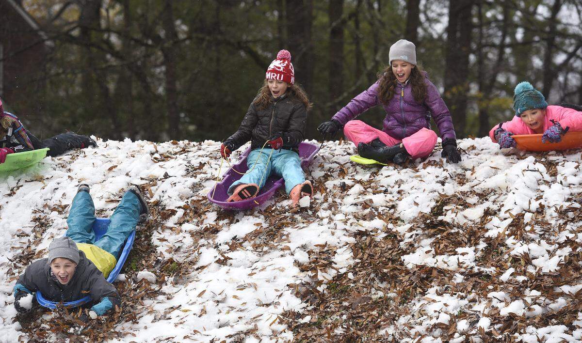From left, Katie Pilon, twins Cecilia Caldwell and Annie Caldwell, and Camilla Hart, slide down a Latta Park hill in Charlotte, NC, on Monday, Dec. 10, 2018.