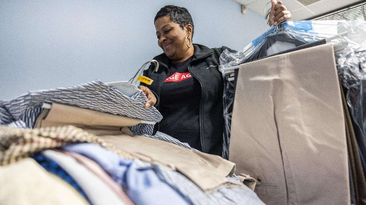 Traletta Banks looks through clothes that were donated to Erika’s Closet in Charlotte, N.C., on Monday, March 13, 2023.