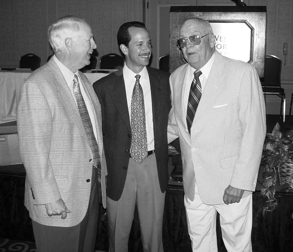 (A younger) Kyle Kallander, center, takes a photo with his Big South Conference commissioner predecessor, Buddy Sasser, and another Big South dignitary.