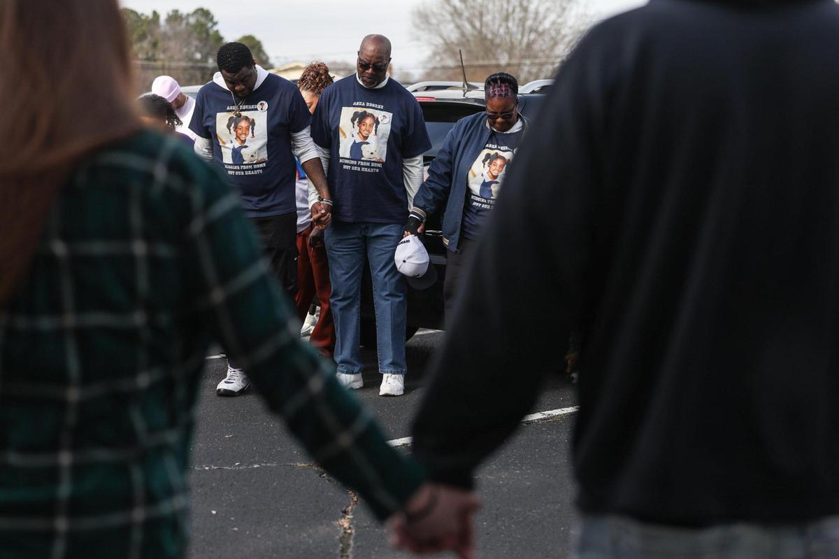 Friends and family pray before beginning a march on Fallston Road to commemorate the 25th year of Asha Degree going missing in Shelby, N.C., on Saturday, Feb. 8, 2025.