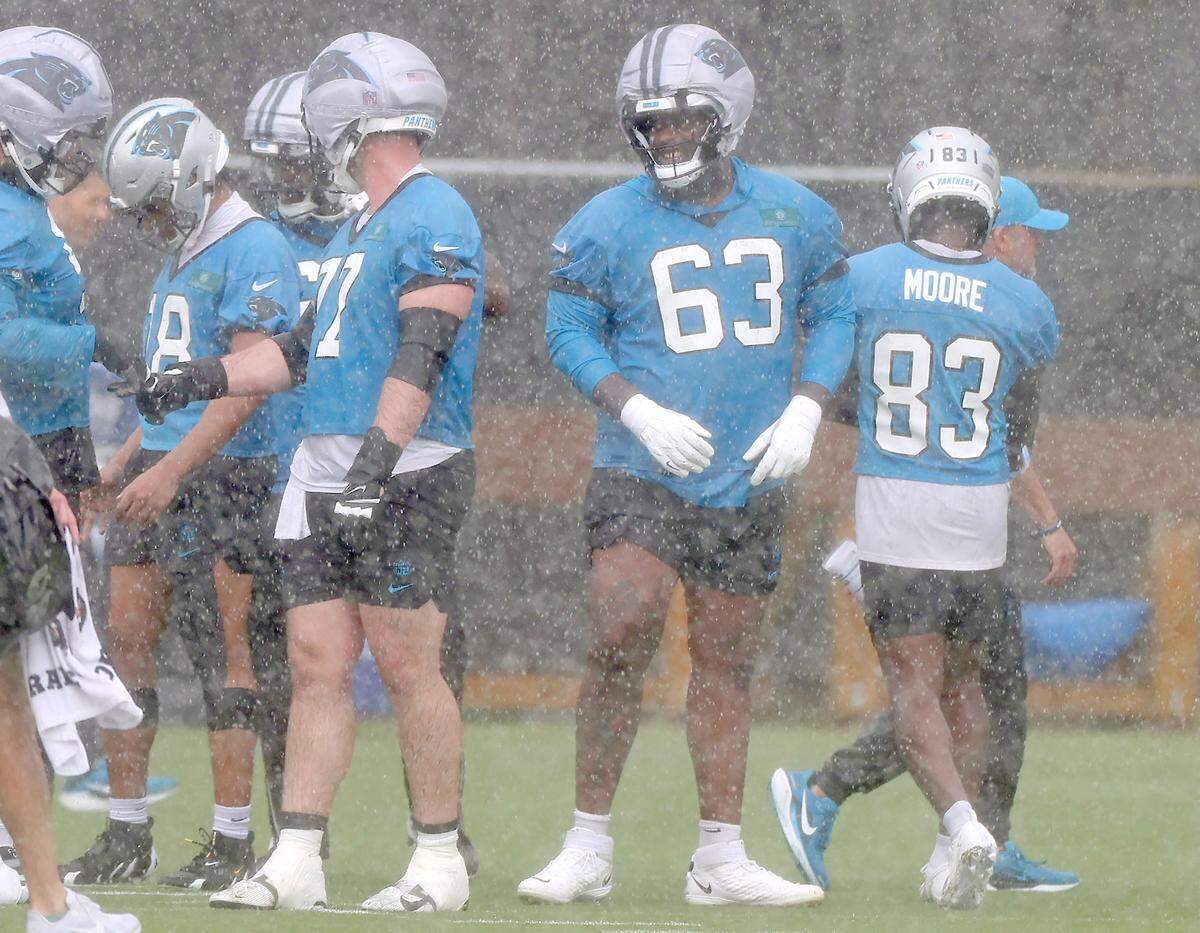 Carolina Panthers tackle Rasheed Walker, right, waits to begin a series of plays during a downpour at the team's first open workout on Tuesday, May 26, 2026.
