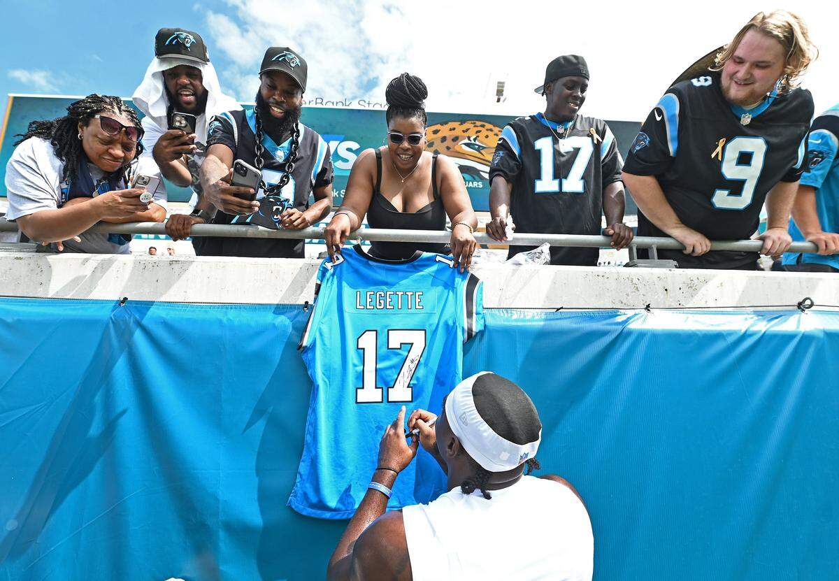Carolina Panthers wide receiver Xavier Legette, center, stops to sign autographs for fans prior to action against the Jacksonville Jaguars on Sunday, September 7, 2025 at Everbank Stadium in Jacksonville, Florida.