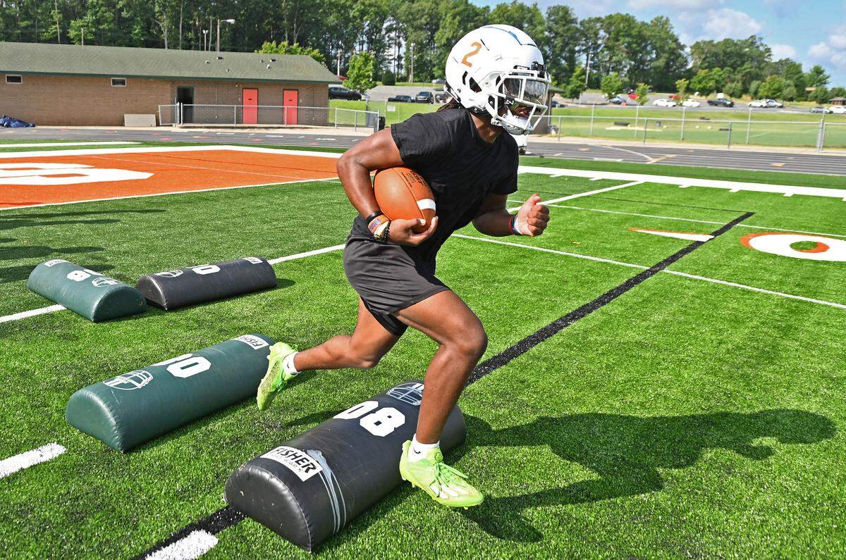 East Lincoln Mustangs running back Chris Daley jumps over a pad during practice at East Lincoln High School in Denver, NC on Monday, July 31, 2023. High school football practices officially began on Monday. East Lincoln was an unbeaten state champion last season and is expected to challenge for another title this season.