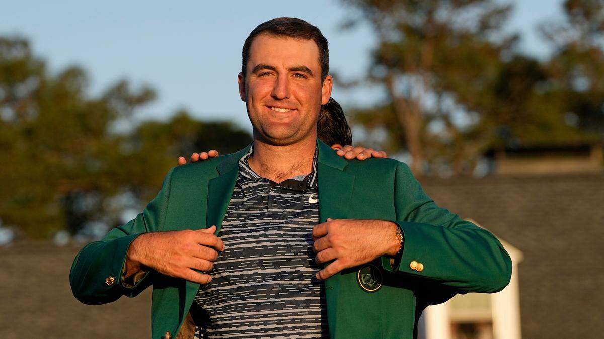 Hideki Matsuyama, of Japan, helps Scottie Scheffler put on the green jacket after winning the 86th Masters golf tournament on Sunday, April 10, 2022, in Augusta, Ga.