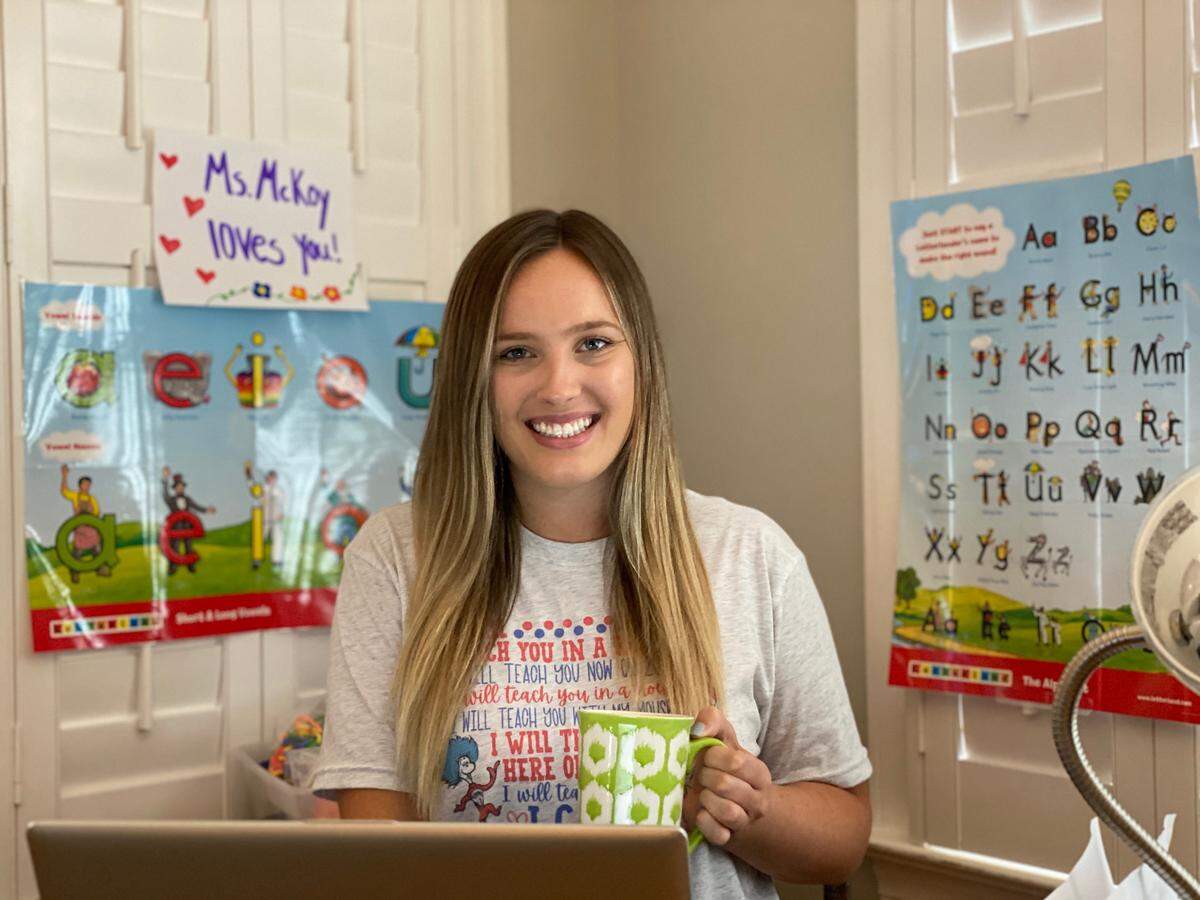 Kindergarten teacher Natalie McKoy has added classroom posters to her living room so her students will feel like they’re in a familiar space when videoconferecing.