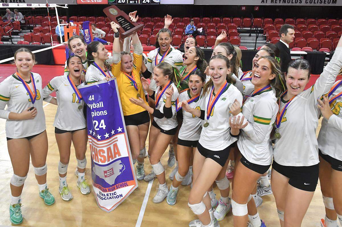 The Cardinal Gibbons Crusaders celebrate with the Championship trophy and banner after defeating Marvin Ridge in the NCHSAA 4A Volleyball Championship game. The Marvin Ridge Mavericks took on the Cardinal Gibbons Crusaders in the NCHSAA 4A Volleyball Championship match in Raleigh, N.C. on November 2, 2024.