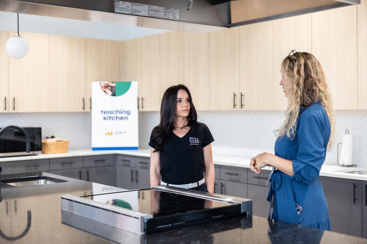 Tina Postel, CEO of Nourish Up, right, gives Nicole Tepper a tour of the new Nourish Up warehouse in Charlotte on Tuesday, June 11, 2024. The Tepper Foundation is donating $3 million to Nourish Up.