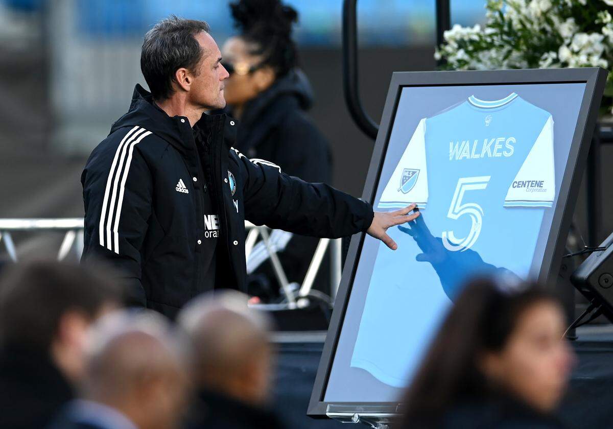 Charlotte FC head coach Christian Lattanzio reaches out to touch the framed jersey of Anton Walkes during a celebration of Walkes’ life at Bank of America Stadium on Tuesday, January 24, 2023. Walkes was a Charlotte FC defender who died from injuries he suffered in a boating accident near the Miami Marine Stadium Basin in Florida on Thursday, January 19, 2023.