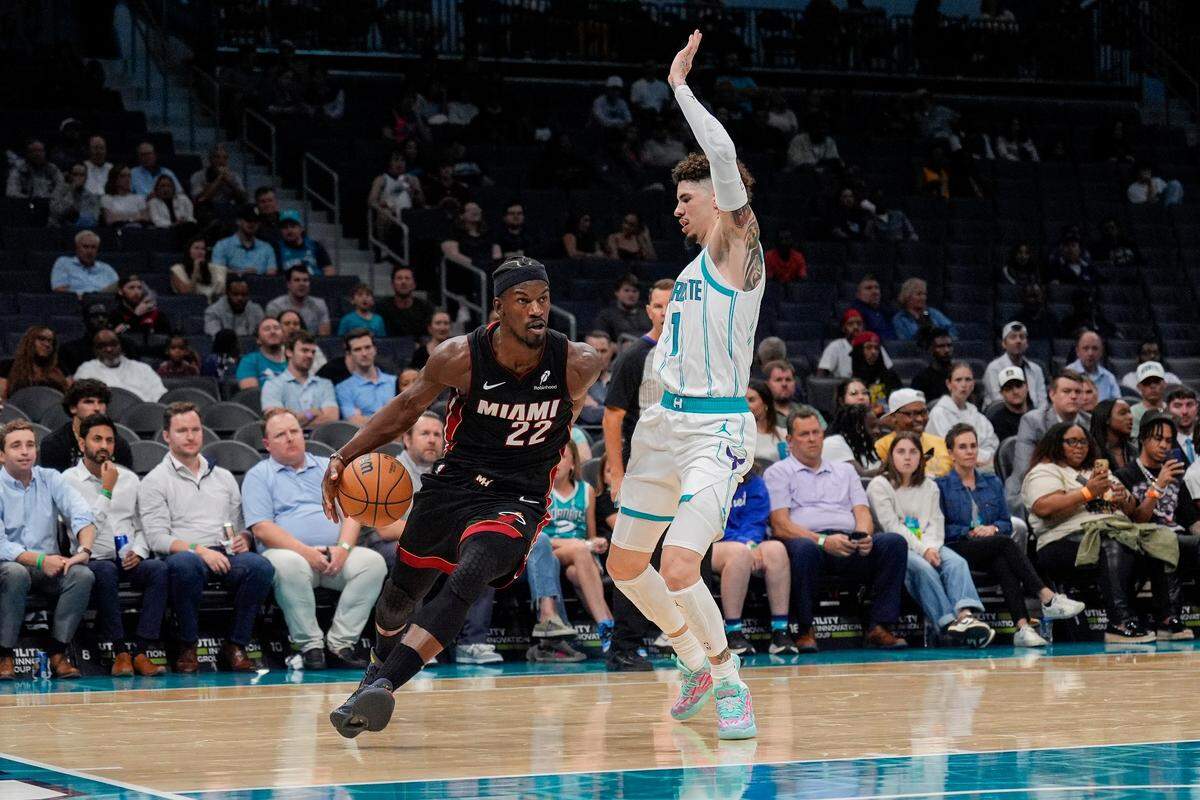 Oct 8, 2024; Charlotte, North Carolina, USA; Miami Heat forward Jimmy Butler (22) drives to the basket against Charlotte Hornets guard LaMelo Ball (1) during the second quarter at Spectrum Center. Mandatory Credit: Jim Dedmon-Imagn Images
