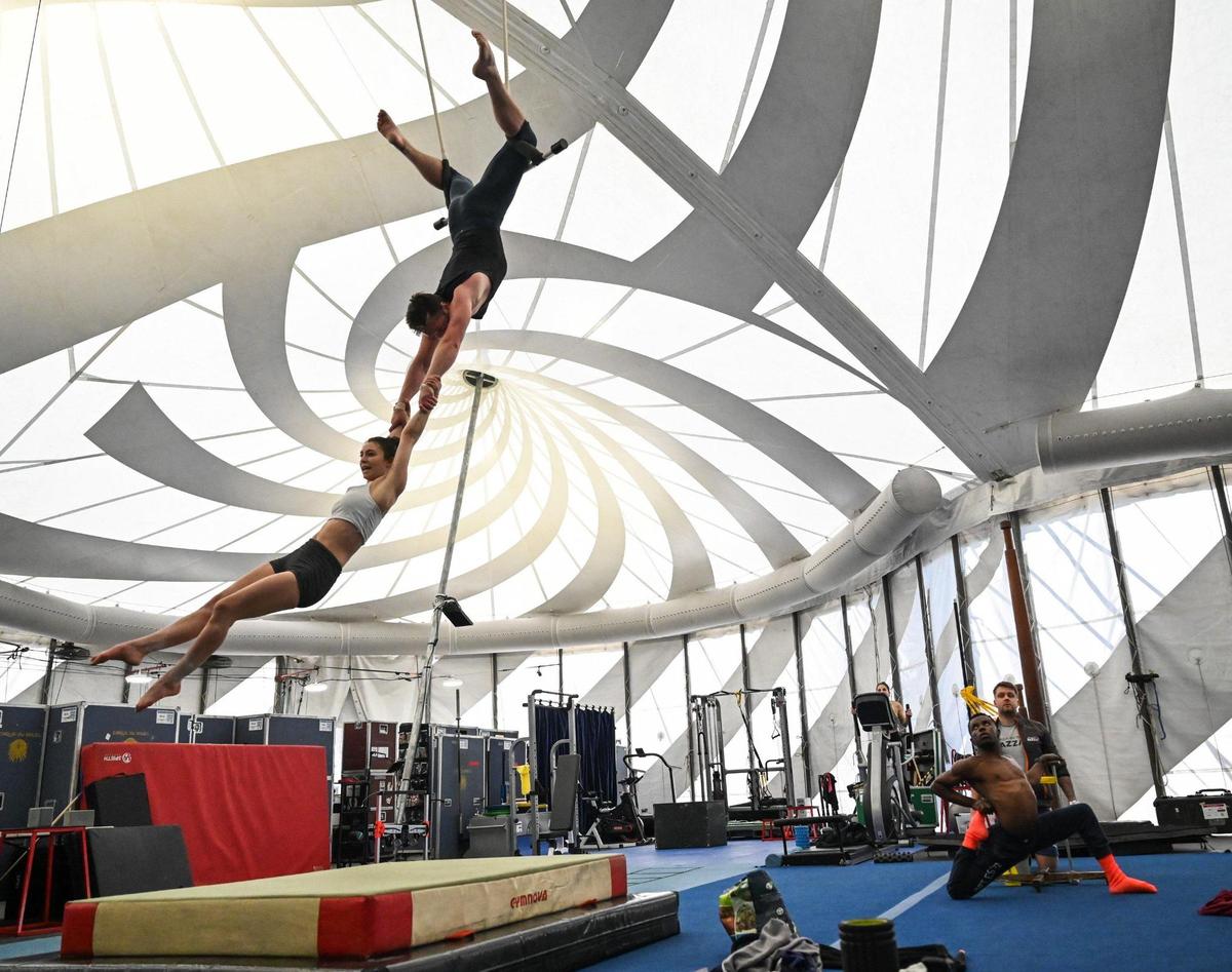 Fellow performers watch as Alexander Taylor holds onto Melanie Dupuis as they hang from a trapeze in the artistic tent for Cirque du Soleil’s “Bazzar” last Friday. Press photographers were not permitted at the actual live shows.