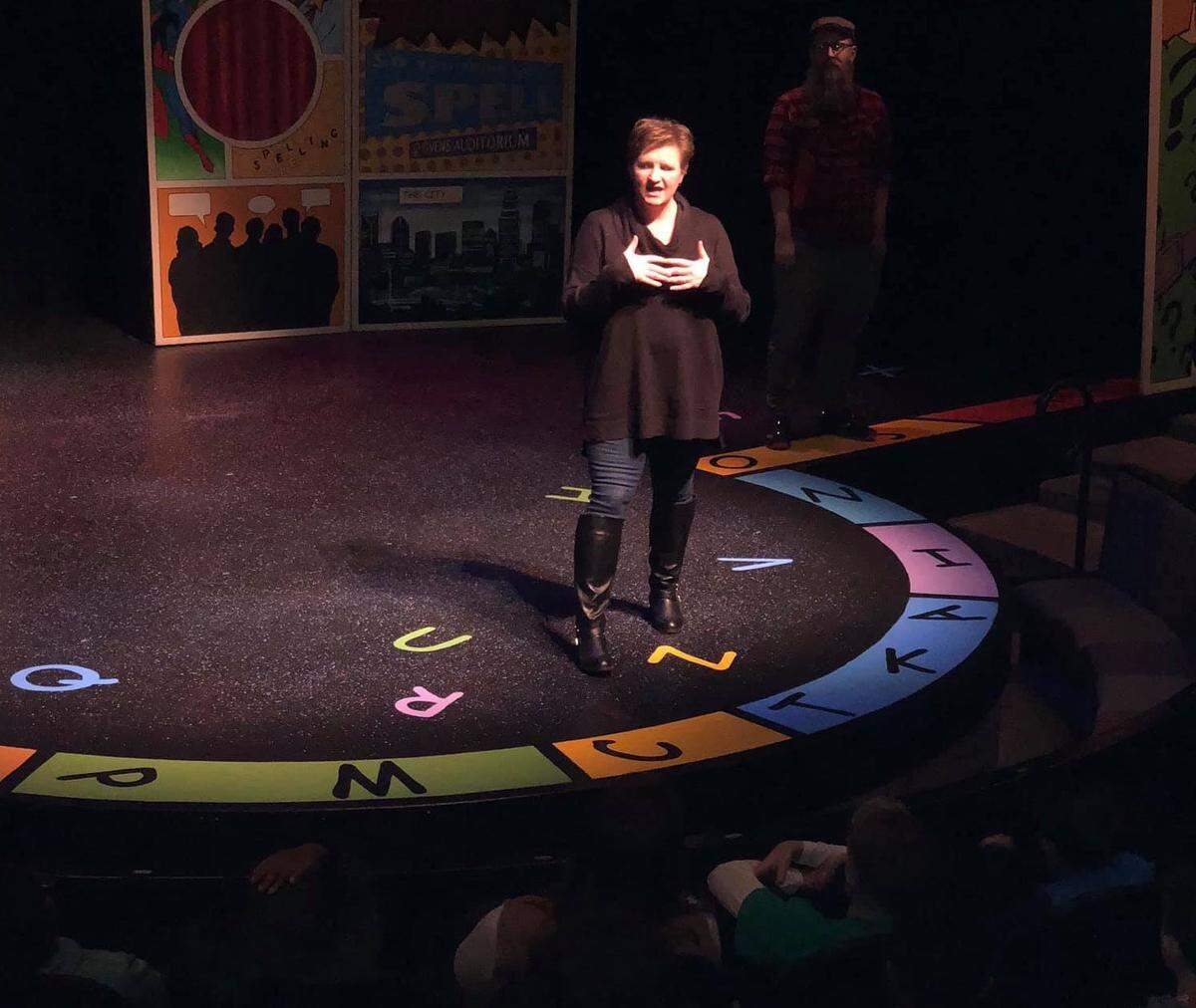 Julie Higginbotham takes the stage to talk to students about sensory-friendly performances and answers questions about autism and other sensory needs after a Children’s Theatre of Charlotte school performance of “Spelling 2-5-5” in 2018. Adam Montague, the Children’s Theatre’s early childhood and School of Theatre Training manager, stands in the background.