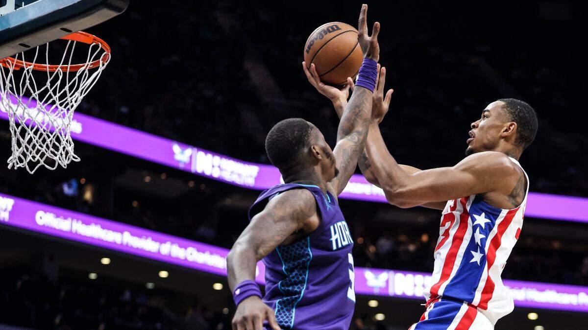 Brooklyn Nets forward Nic Claxton, right, shoots past a block by Charlotte Hornets guard Terry Rozier at the Spectrum Center in Charlotte, N.C., on Saturday, November 5, 2022.