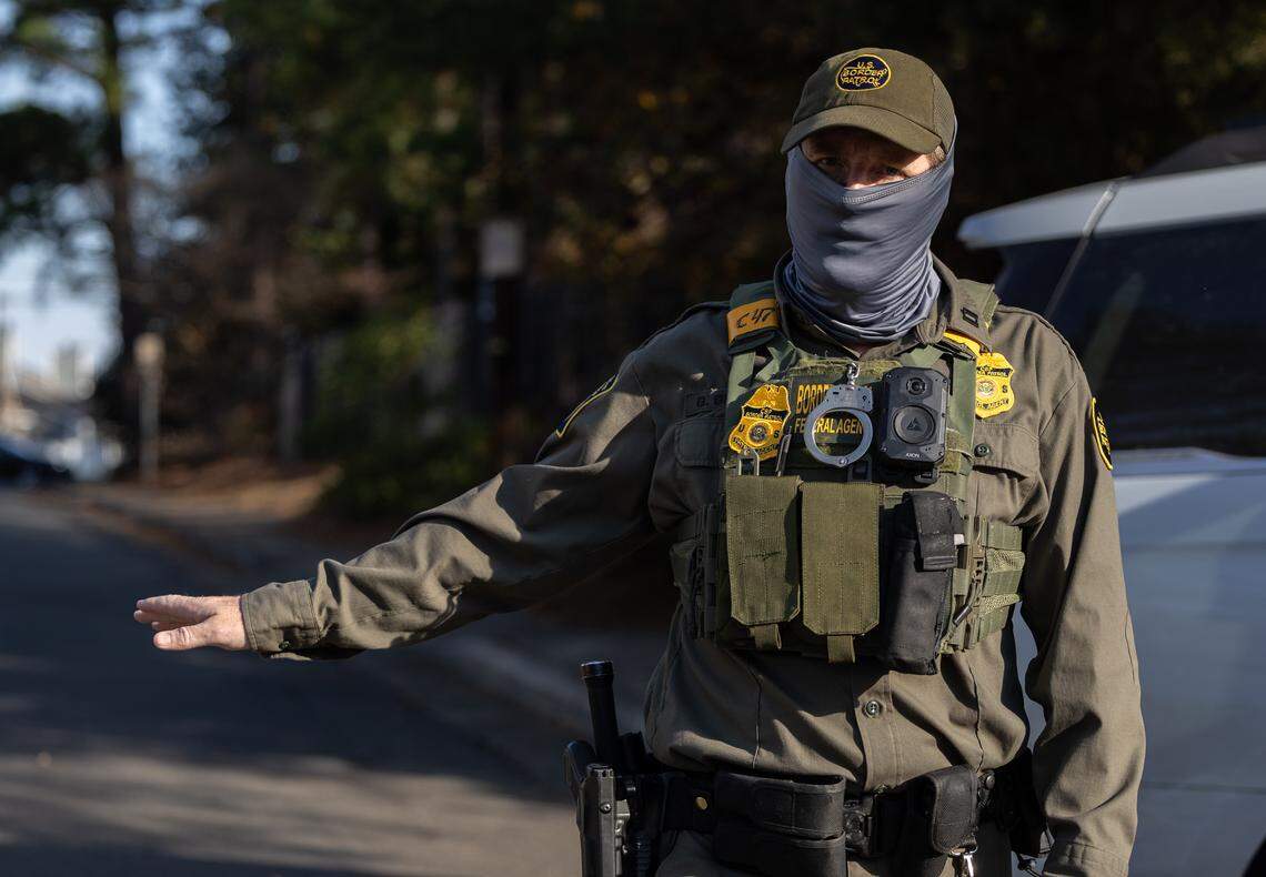 A Border Patrol Agent keeps watch while other agents make an arrest on Sharonbrook Drive in Charlotte, NC on Sunday morning, Nov. 16, 2025.